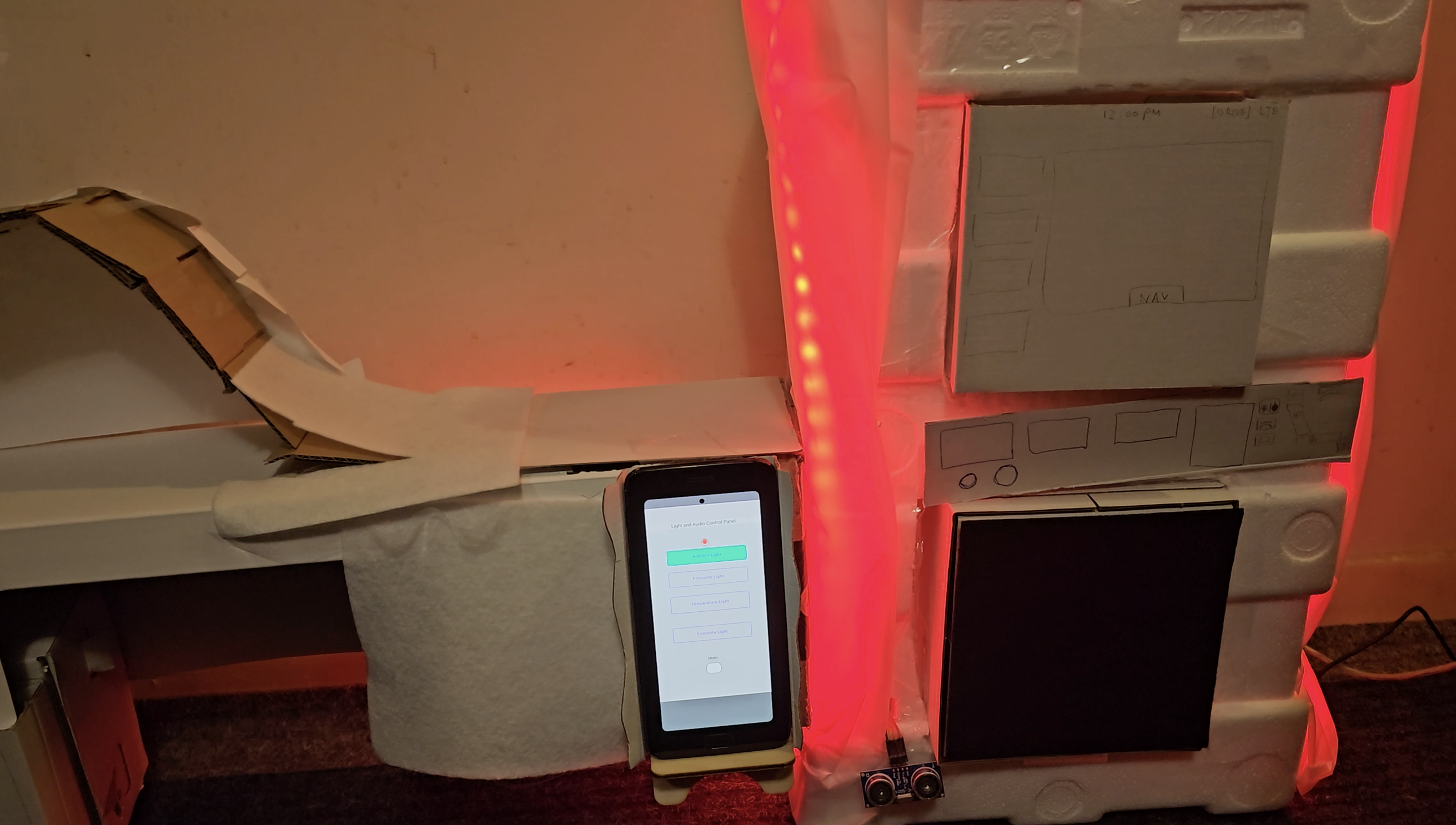 Image of prototype with led strip dimmed, an example digital or physical interface between the two screens. Image is a still of a vido where a light mode is being selected; warm ambient light.